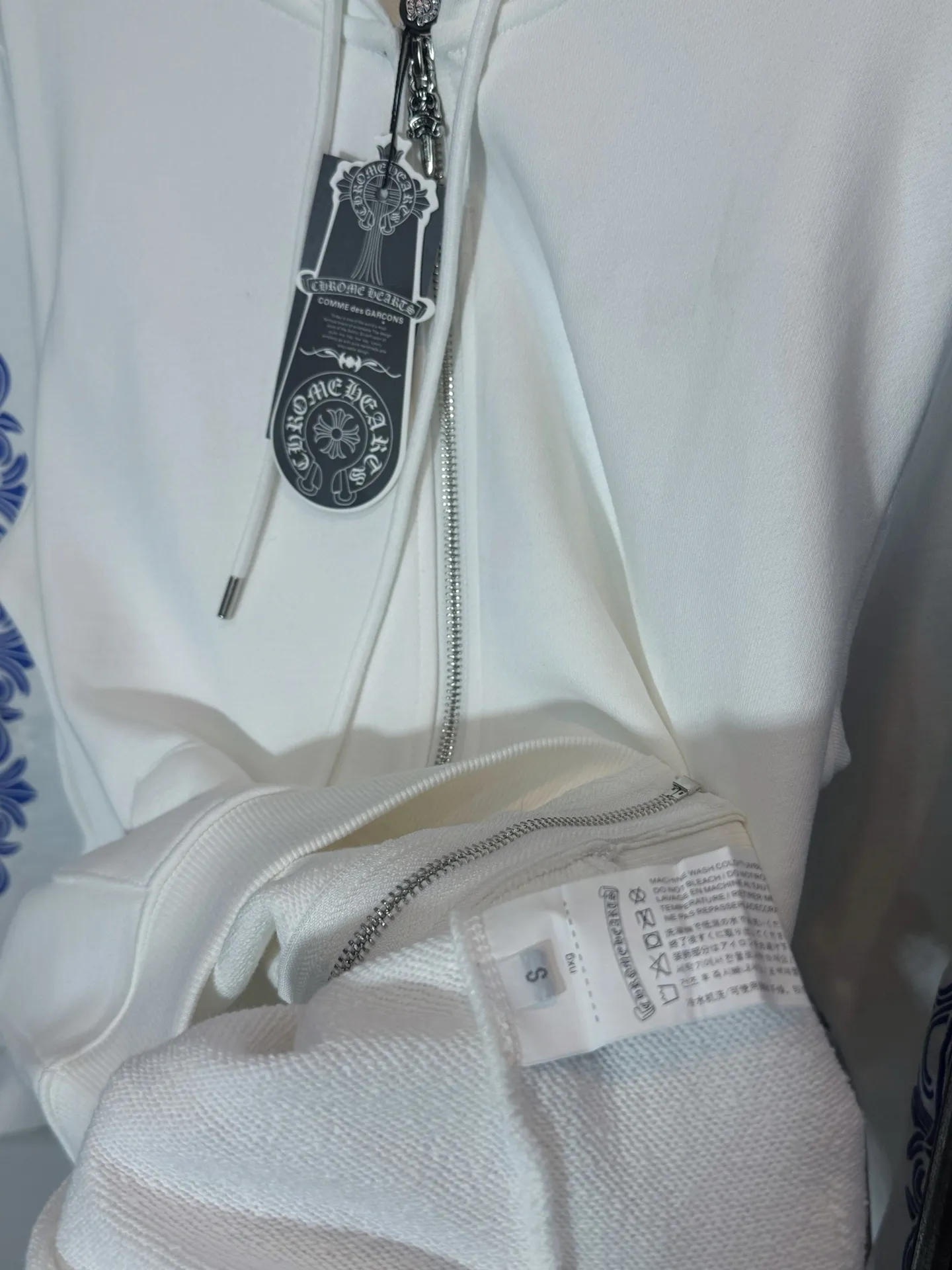 P300 model number: HE390 Chromehearts-Chrome heart blue printed hooded zipper jacket The fabric is made of 420g high-weight pure cotton double-yarn terry fabric. The upper body is warm and comfortable, and the hand feels delicate and smooth. The printing on the back of the arms is made with white ink direct injection process. The blue and white contrasting design highlights the characteristics of the clothes. The original puller zipper of the original Croxin hardware is customized. The threads of the arm hem are elastic threads of the same color in the same cylinder. It is made by a large factory and has the original original label. It is complete with three labels. You can buy it with confidence.  Color: White Size: S M L XL